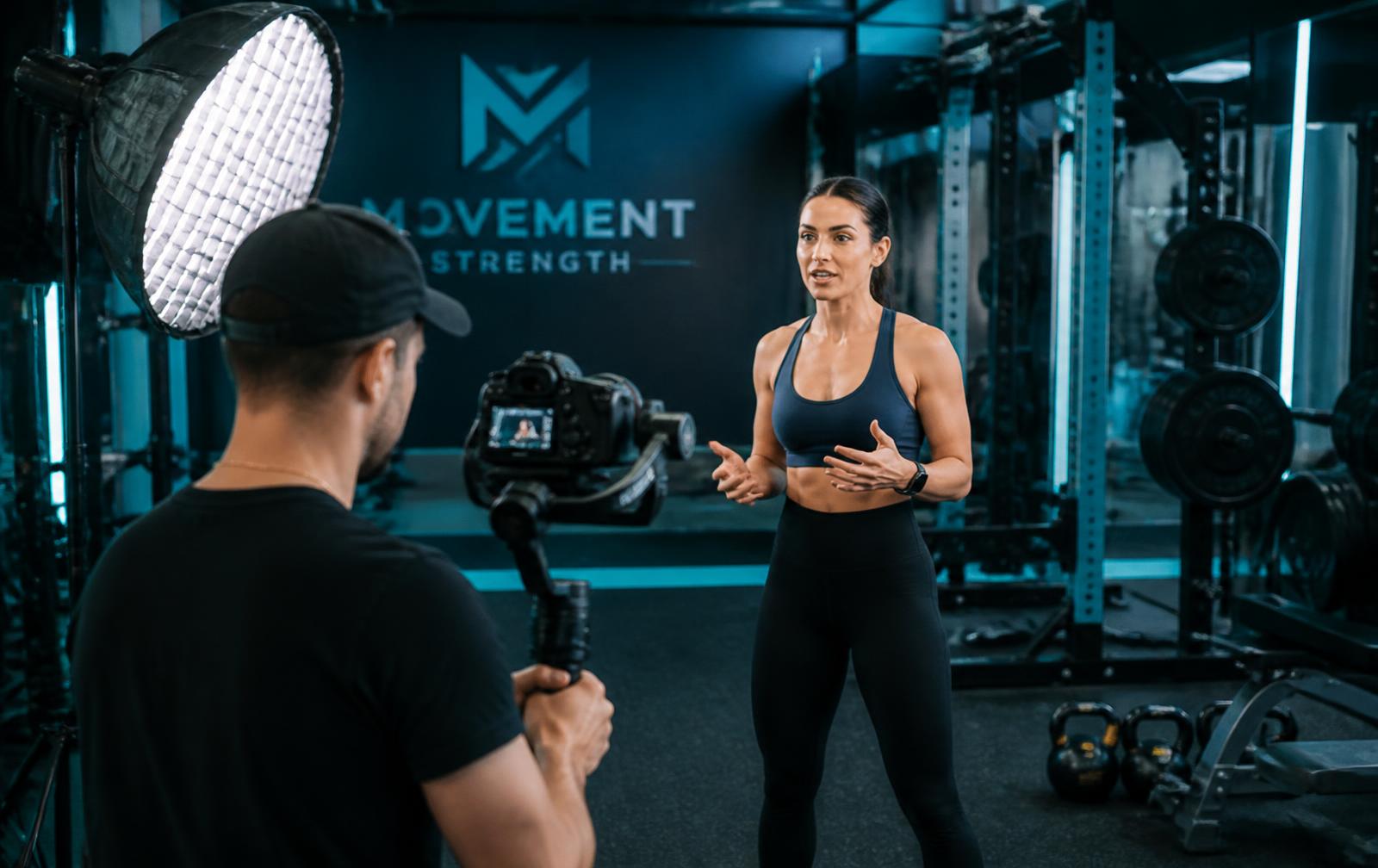 Video crew filming a fitness trainer in a gym